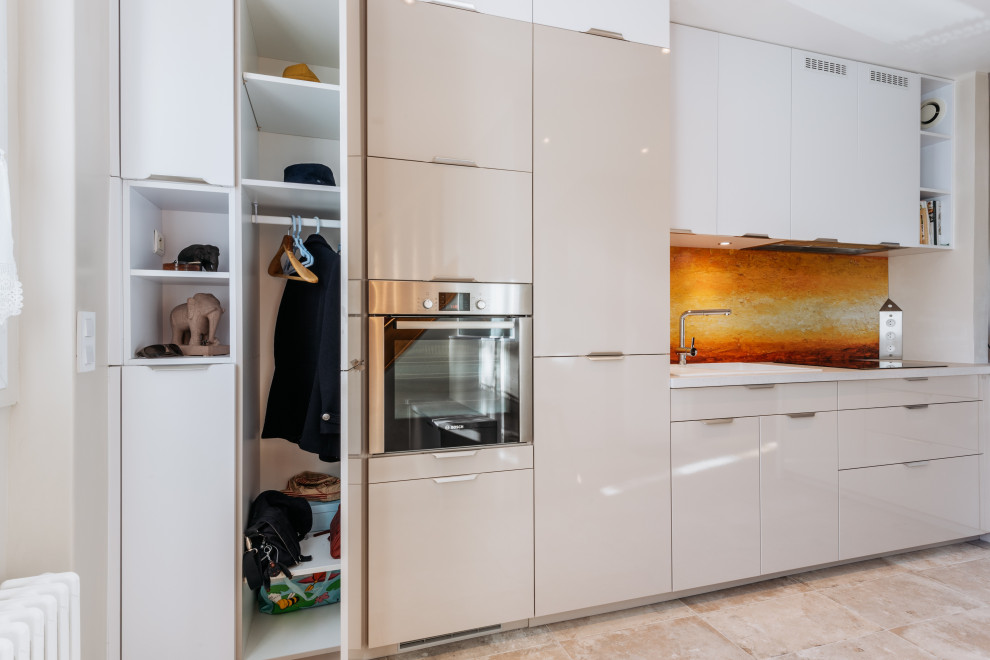 Photo of a medium sized contemporary l-shaped open plan kitchen in Paris with a submerged sink, beaded cabinets, beige cabinets, orange splashback, stainless steel appliances, ceramic flooring and beige floors.