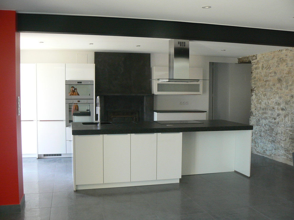 Exempel på ett stort modernt kök, med en integrerad diskho, släta luckor, vita skåp, bänkskiva i kvartsit, rostfria vitvaror, klinkergolv i keramik och en köksö