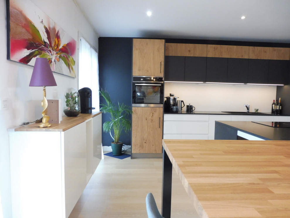 Foto de cocina urbana grande abierta con fregadero de doble seno, encimera de granito, salpicadero blanco, electrodomésticos con paneles, una isla y encimeras negras