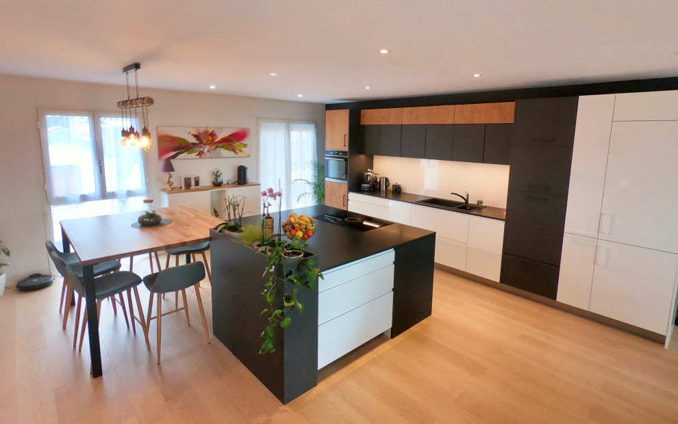 Example of a large urban open concept kitchen design in Other with a double-bowl sink, granite countertops, white backsplash, paneled appliances, an island and black countertops