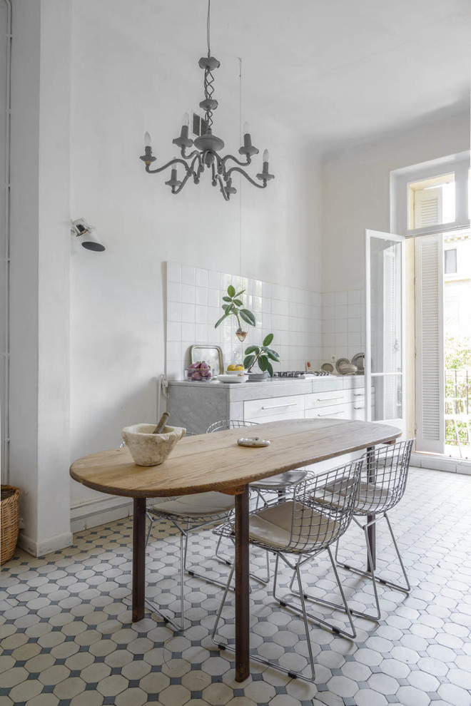 Einzeilige, Große Mediterrane Wohnküche ohne Insel mit weißen Schränken, Küchenrückwand in Weiß und Rückwand aus Keramikfliesen in Marseille