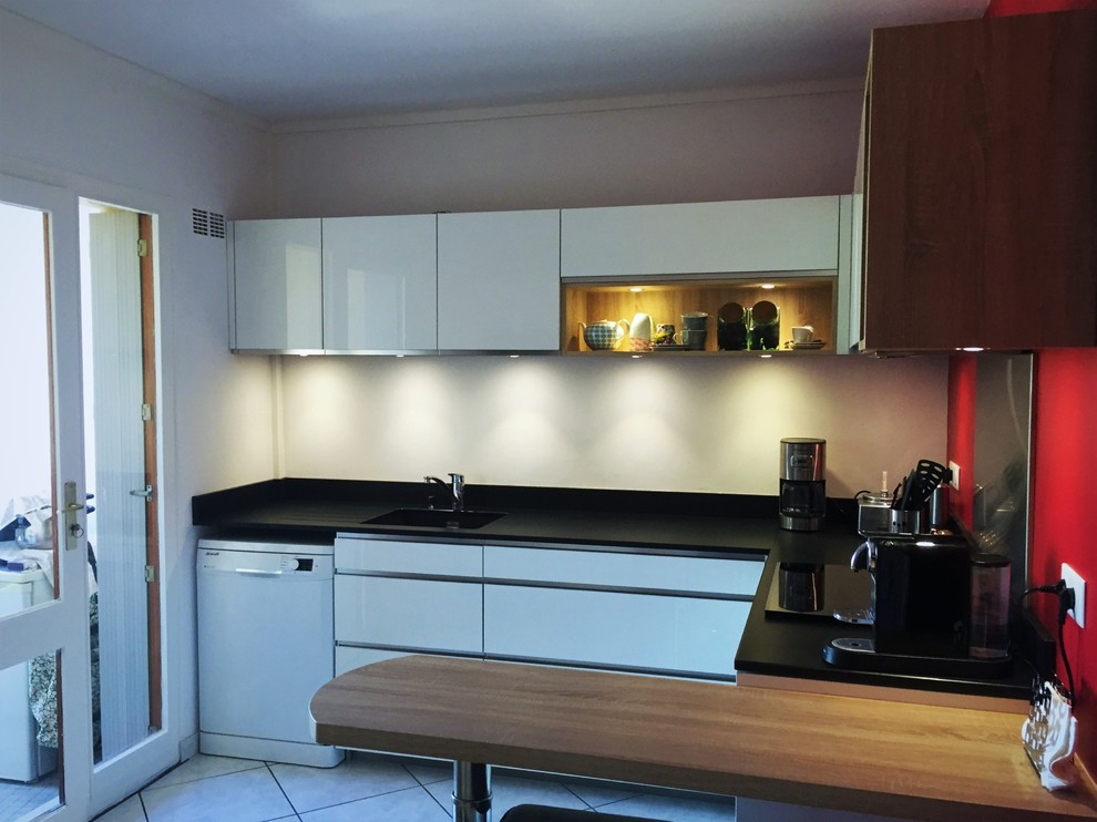 Inspiration for a medium sized modern l-shaped enclosed kitchen in Bordeaux with an integrated sink, flat-panel cabinets, white cabinets, granite worktops, black splashback, ceramic flooring and no island.