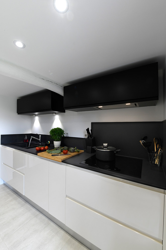 Foto de cocina minimalista con salpicadero negro y encimeras negras