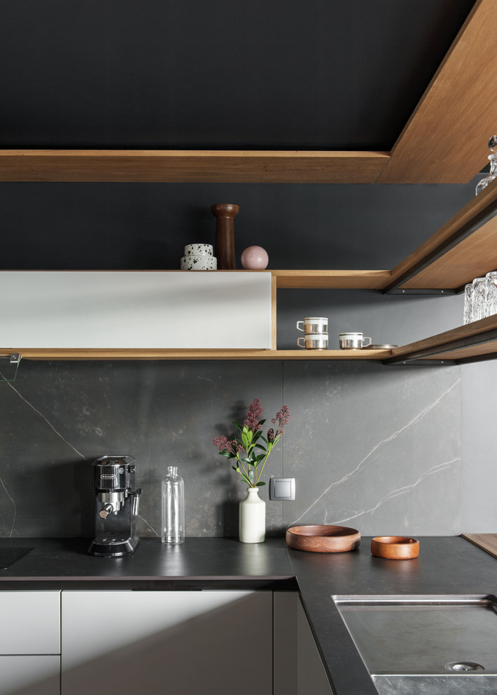 Inspiration for a medium sized contemporary u-shaped kitchen/diner in Nantes with a double-bowl sink, beaded cabinets, white cabinets, granite worktops, black splashback, stainless steel appliances, no island and black worktops.