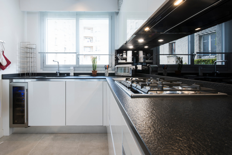 Inspiration för mellanstora moderna kök, med granitbänkskiva, svart stänkskydd och en köksö