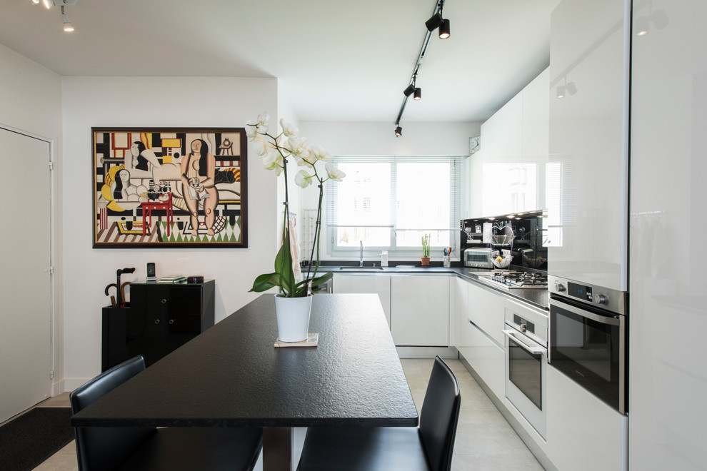 Cette image montre une cuisine ouverte design en L de taille moyenne avec un plan de travail en granite, une crédence noire et îlot.