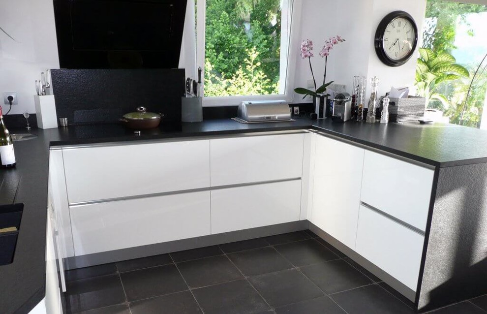 Esempio di una cucina minimalista di medie dimensioni con ante di vetro, ante nere, top in granito, elettrodomestici in acciaio inossidabile, penisola, pavimento nero e top nero
