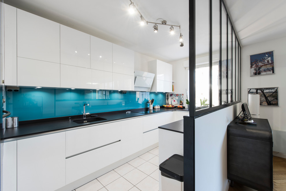 Immagine di una cucina ad U design di medie dimensioni con lavello sottopiano, top in granito, paraspruzzi blu e pavimento con piastrelle in ceramica