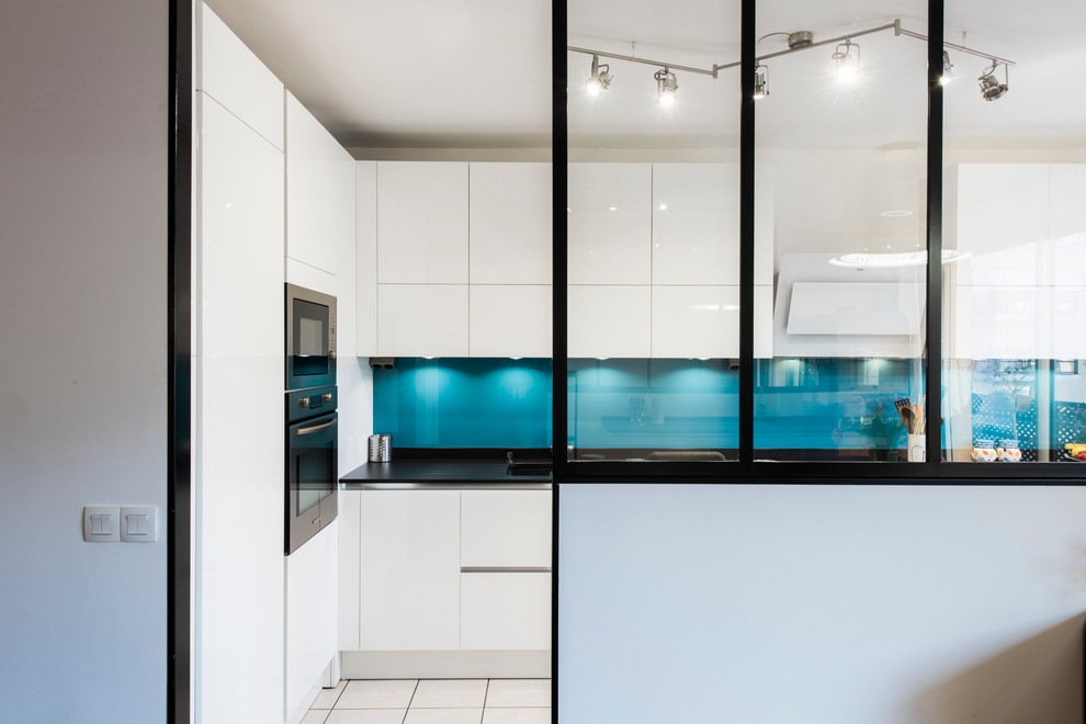 Immagine di una cucina ad U minimal di medie dimensioni con lavello sottopiano, top in granito, paraspruzzi blu e pavimento con piastrelle in ceramica