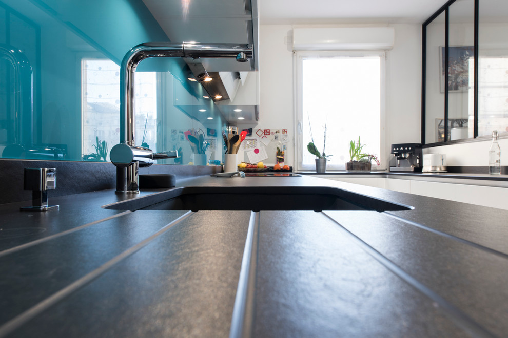 Imagen de cocinas en U actual de tamaño medio con fregadero bajoencimera, encimera de granito, salpicadero azul y suelo de baldosas de cerámica