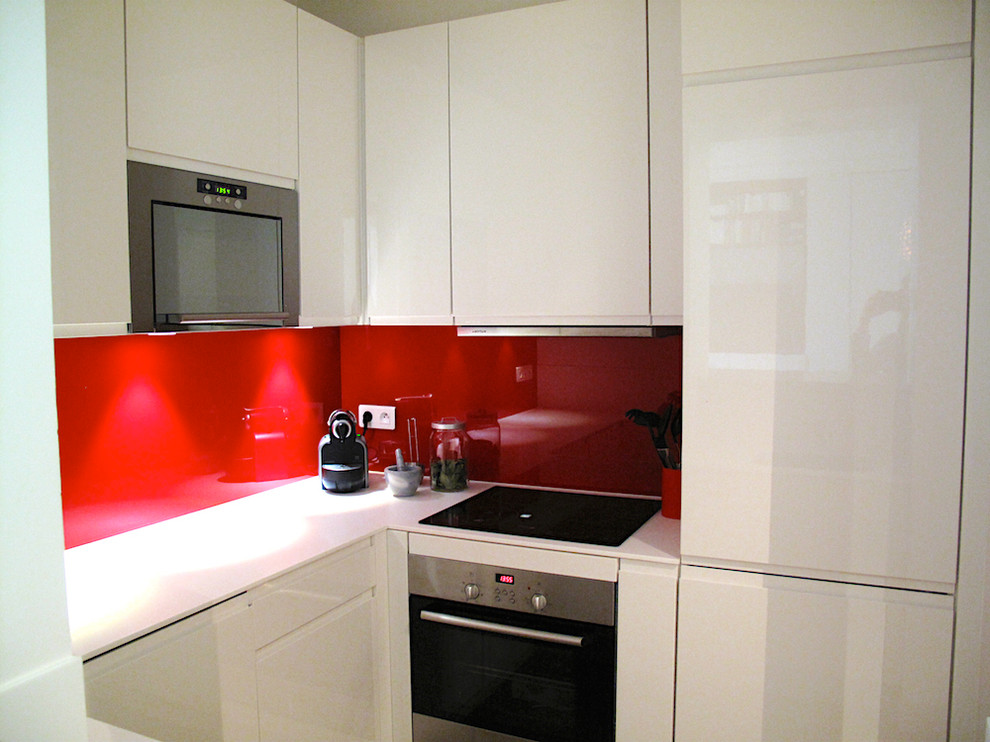 Bild på ett litet eklektiskt vit vitt kök, med en undermonterad diskho, luckor med profilerade fronter, vita skåp, rött stänkskydd, glaspanel som stänkskydd, rostfria vitvaror, betonggolv, grått golv och bänkskiva i koppar