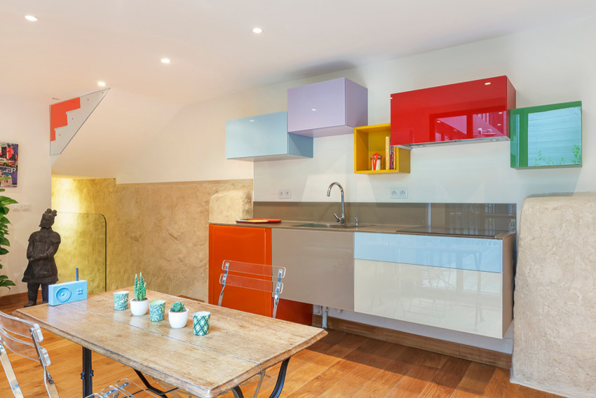 This is an example of a small contemporary single-wall kitchen/diner in Paris with a single-bowl sink, glass worktops, brown splashback, glass tiled splashback, integrated appliances, light hardwood flooring and no island.
