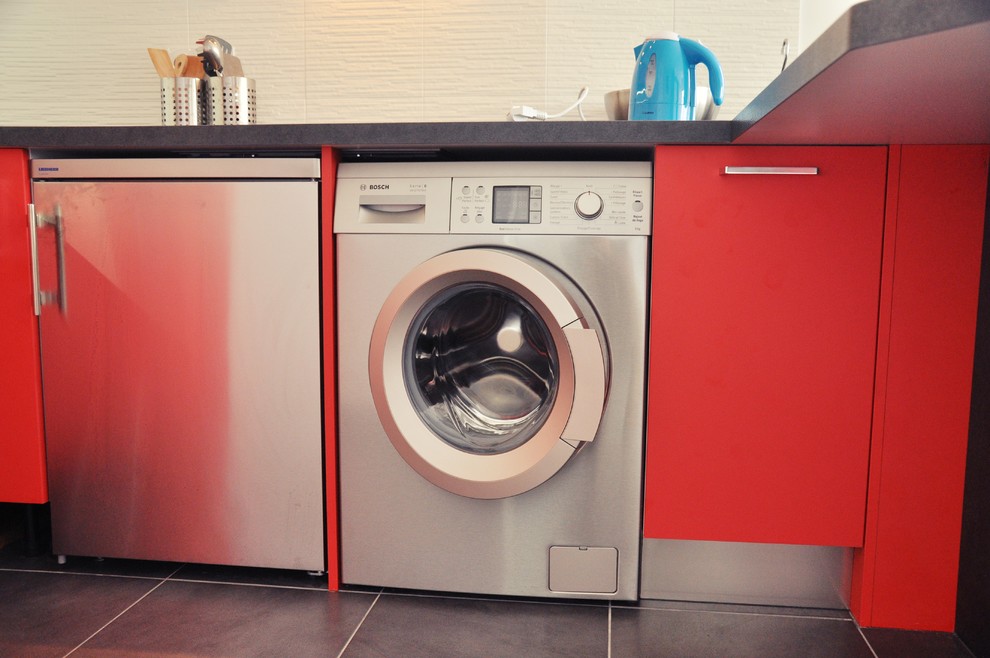Kleine Moderne Wohnküche in U-Form mit Unterbauwaschbecken, roten Schränken, Küchenrückwand in Schwarz, Küchengeräten aus Edelstahl und Porzellan-Bodenfliesen in Montpellier