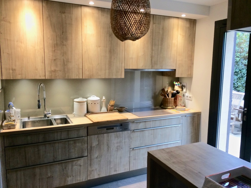 Photo of a medium sized contemporary l-shaped open plan kitchen in Other with a double-bowl sink, beaded cabinets, medium wood cabinets, laminate countertops, grey splashback, glass tiled splashback, stainless steel appliances, ceramic flooring, a breakfast bar, grey floors and grey worktops.