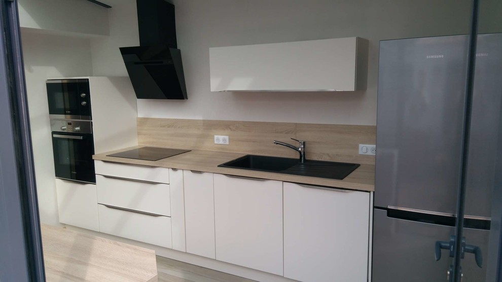 Contemporary kitchen in Nantes with a submerged sink, laminate countertops, beige splashback, stainless steel appliances, multiple islands and beige floors.