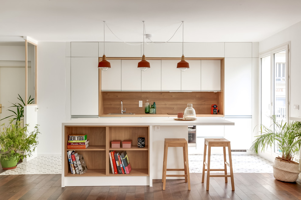 Foto på ett stort funkis kök, med en enkel diskho, luckor med profilerade fronter, vita skåp, laminatbänkskiva, integrerade vitvaror, cementgolv, en köksö, vitt golv och vitt stänkskydd