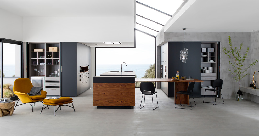 Свежая идея для дизайна: огромная угловая кухня в современном стиле с обеденным столом, фасадами в стиле шейкер, черными фасадами, бетонным полом и островом - отличное фото интерьера