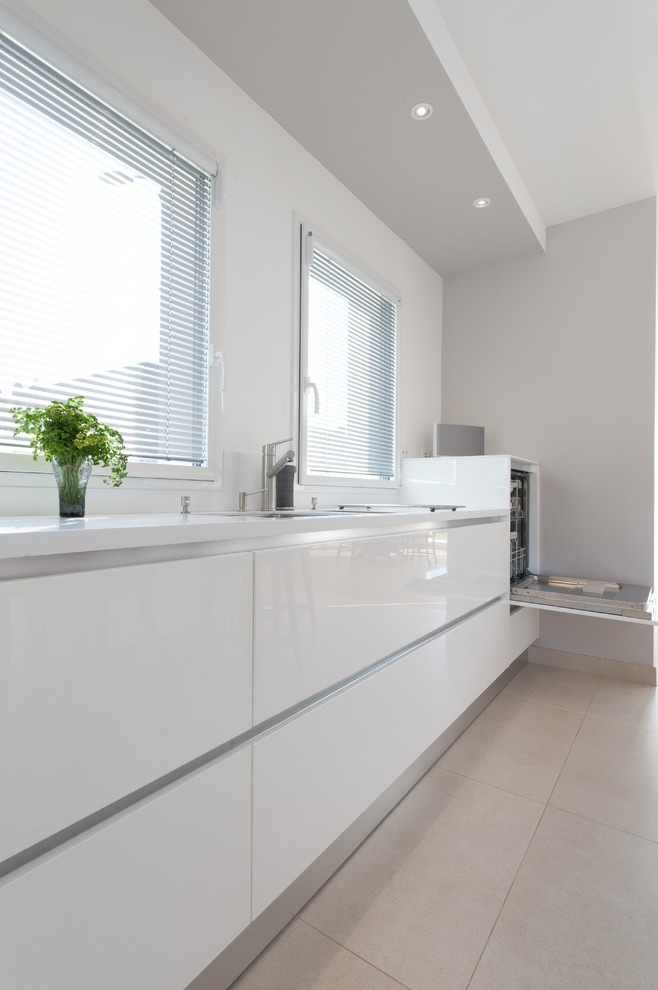 Photo of a large modern single-wall open plan kitchen in Paris with beaded cabinets, white cabinets, quartz worktops, integrated appliances and an island.