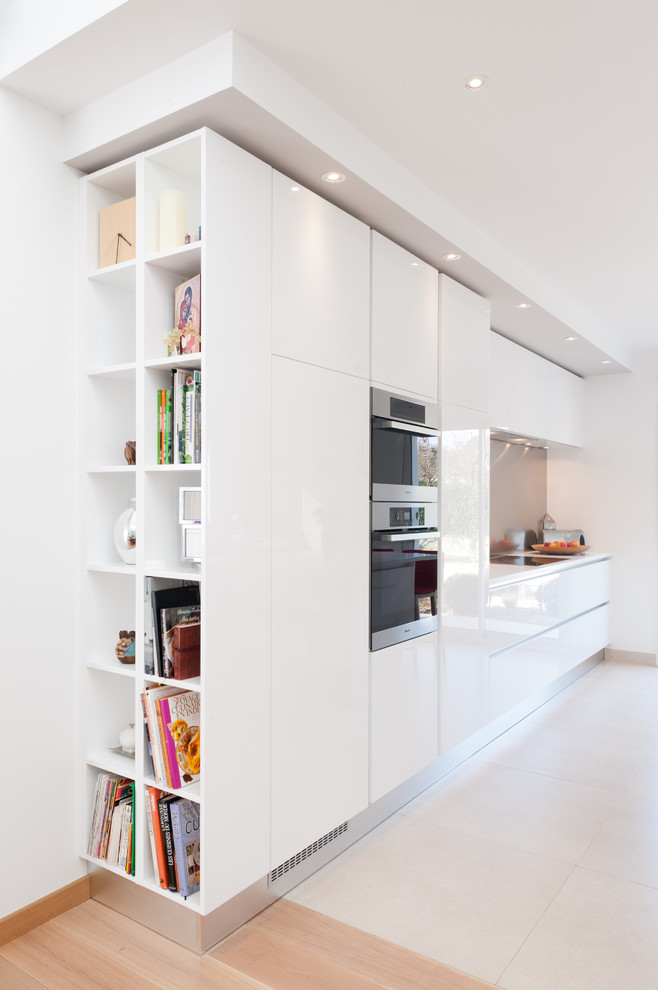 パリにある高級な広いコンテンポラリースタイルのおしゃれなI型キッチン (白いキャビネット、グレーのキッチンパネル、インセット扉のキャビネット、珪岩カウンター、メタルタイルのキッチンパネル、パネルと同色の調理設備) の写真