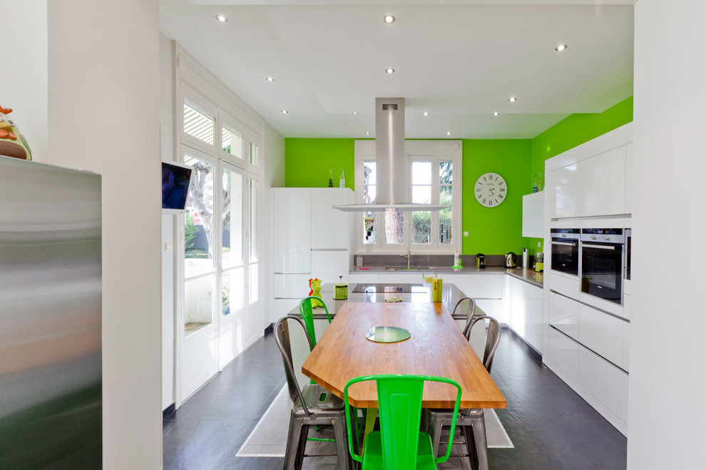 Photo of a large contemporary l-shaped kitchen/diner in Rennes with a submerged sink, white cabinets, integrated appliances, ceramic flooring and an island.
