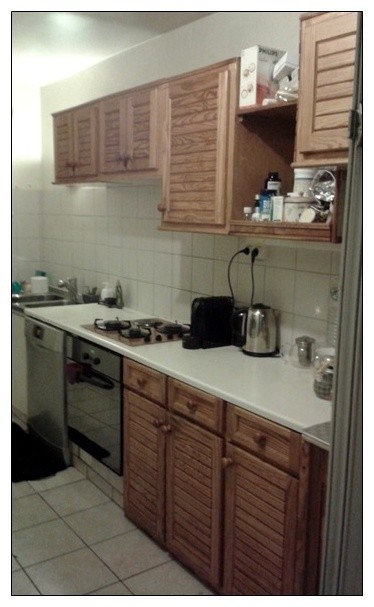Foto di una cucina parallela minimal chiusa e di medie dimensioni con lavello sottopiano, ante lisce, paraspruzzi nero, elettrodomestici in acciaio inossidabile, parquet chiaro, nessuna isola e top nero