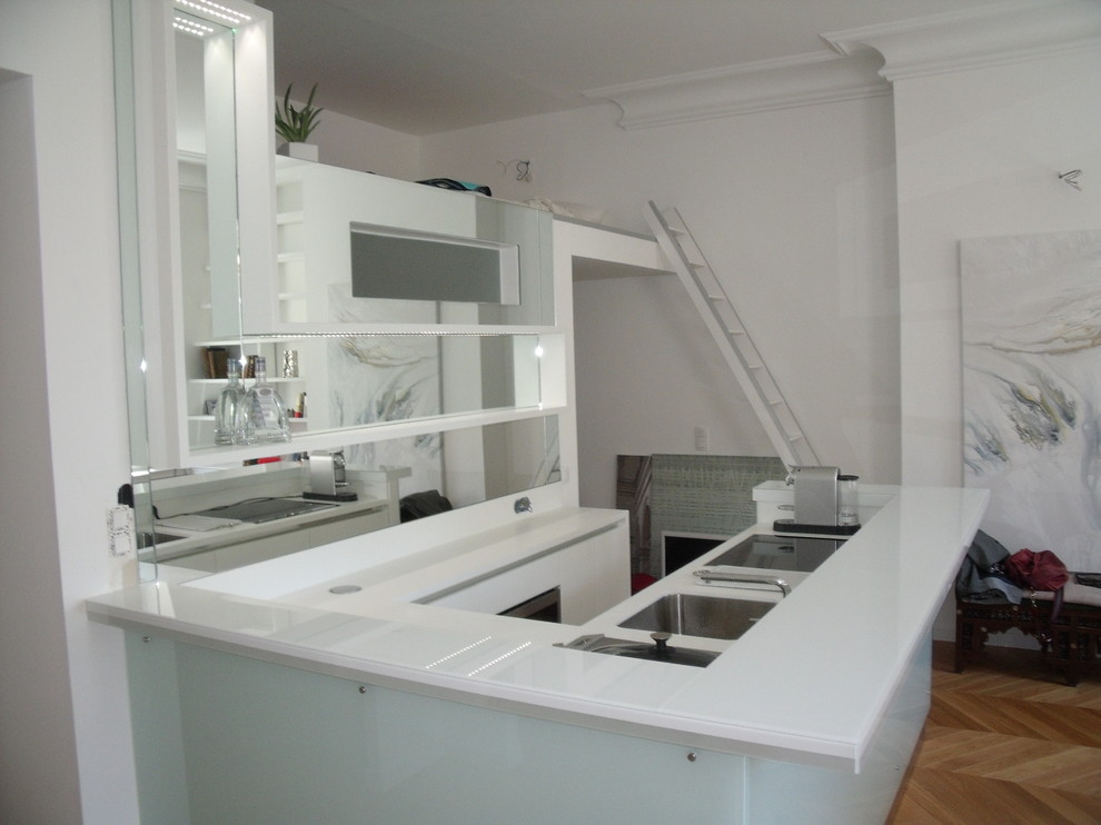 Foto di una piccola cucina ad U contemporanea con ante bianche e paraspruzzi a specchio