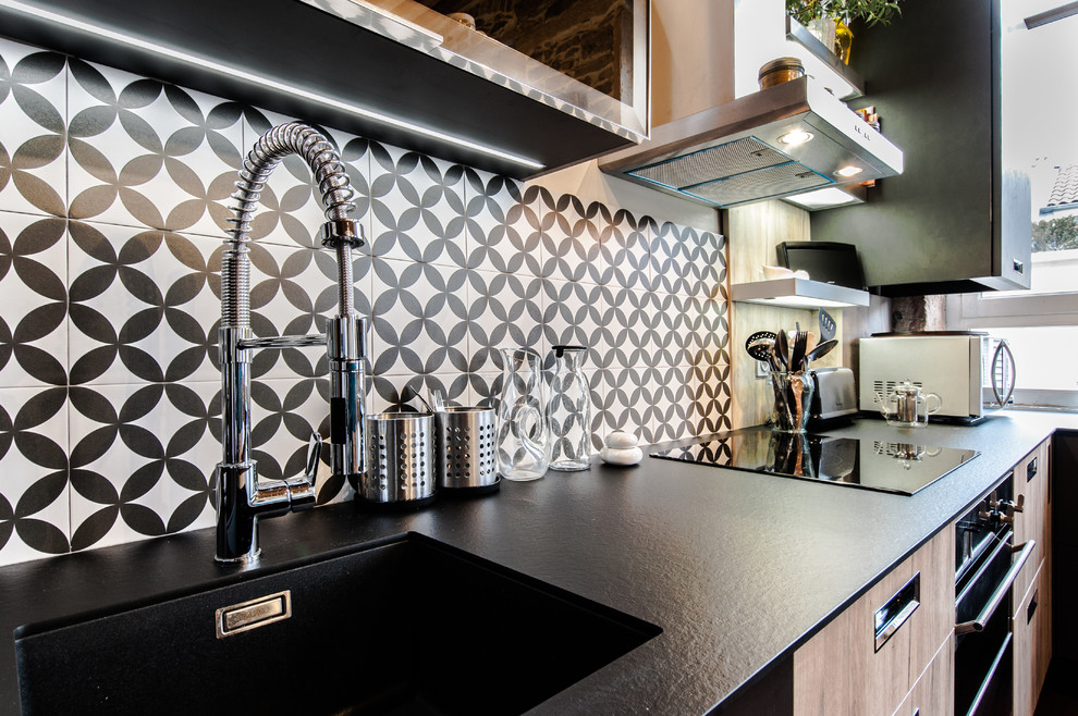 Imagen de cocina urbana de tamaño medio con puertas de armario de madera clara, encimera de acrílico, salpicadero de azulejos de cemento y electrodomésticos de acero inoxidable