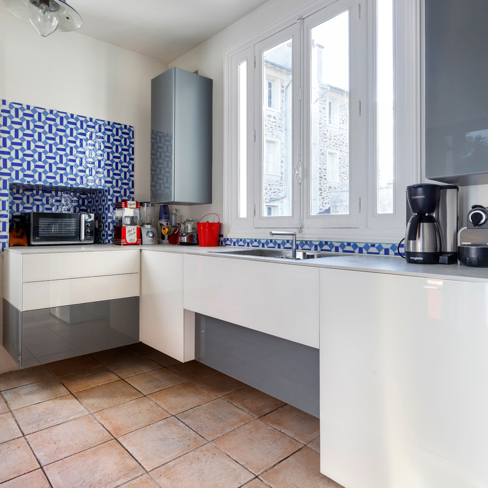 Example of a mid-sized trendy l-shaped enclosed kitchen design in Paris with flat-panel cabinets, white cabinets, blue backsplash and no island