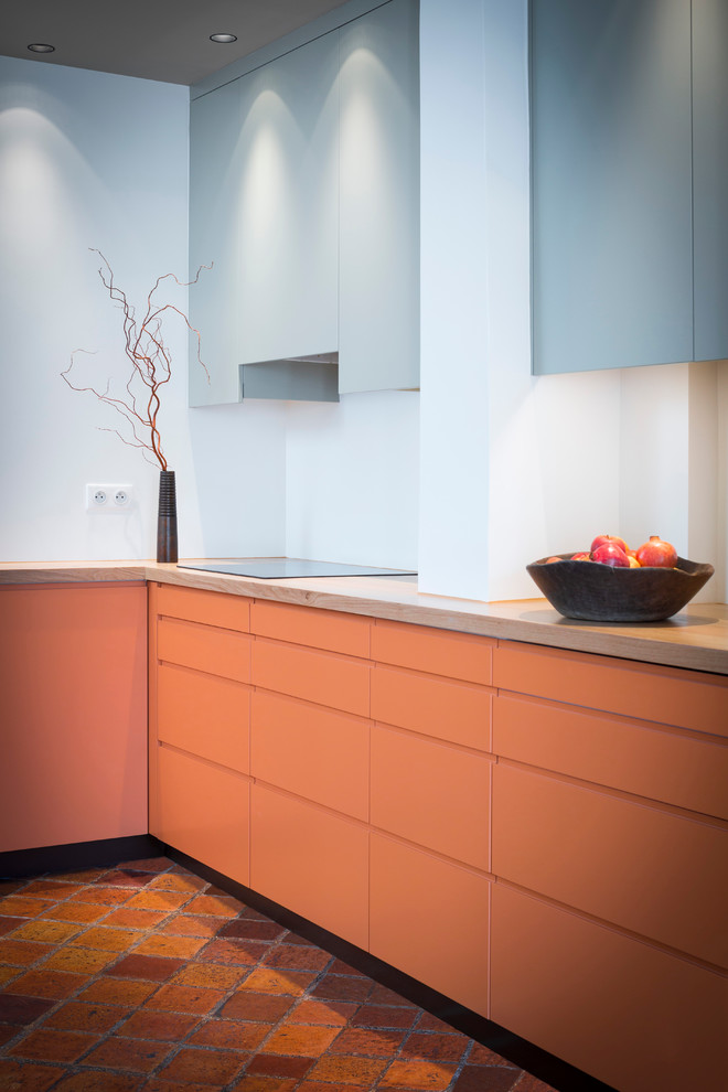 Пример оригинального дизайна: большая отдельная, угловая кухня в современном стиле с оранжевыми фасадами без острова