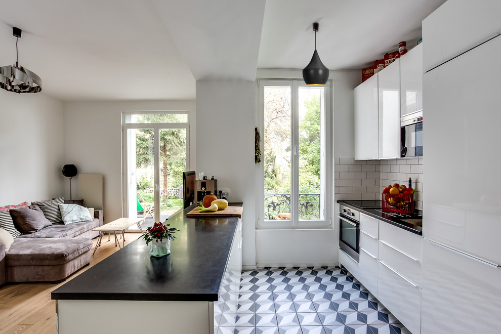 Cette image montre une cuisine minimaliste avec des portes de placard blanches, plan de travail en marbre, un électroménager blanc et parquet clair.