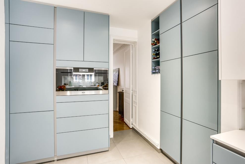 Geschlossene, Zweizeilige, Mittelgroße Moderne Küche mit Küchenrückwand in Blau, Elektrogeräten mit Frontblende, Zementfliesen für Boden und beigem Boden in Paris