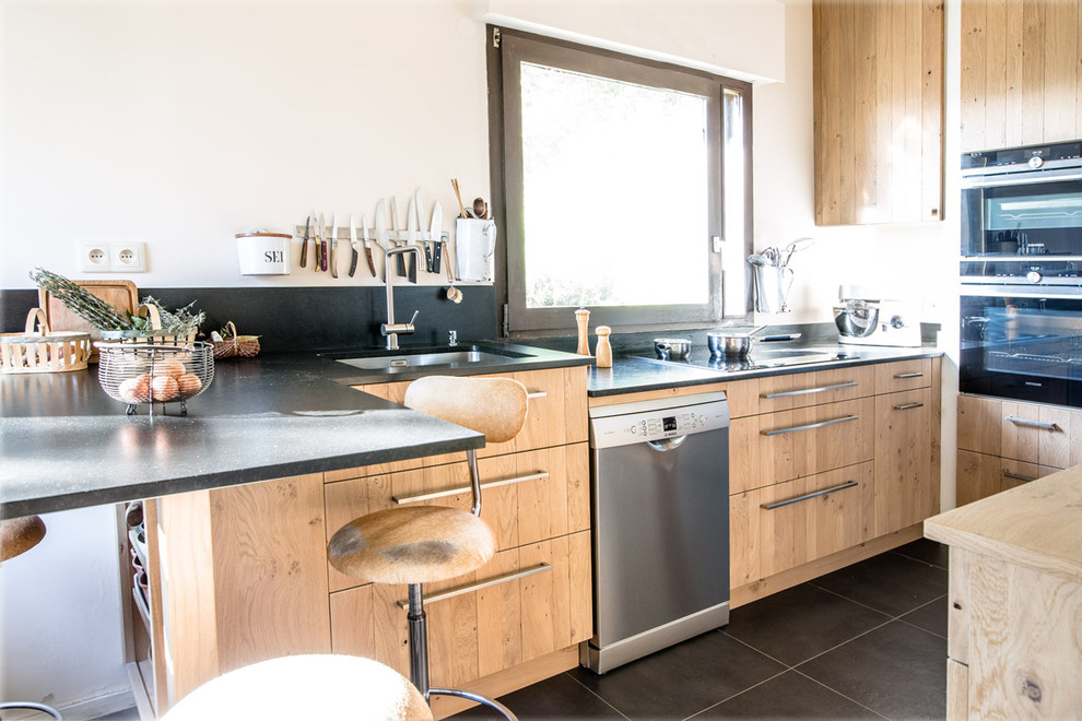 Immagine di una cucina rustica di medie dimensioni con lavello a vasca singola, top in granito, elettrodomestici in acciaio inossidabile, pavimento in cementine e pavimento nero