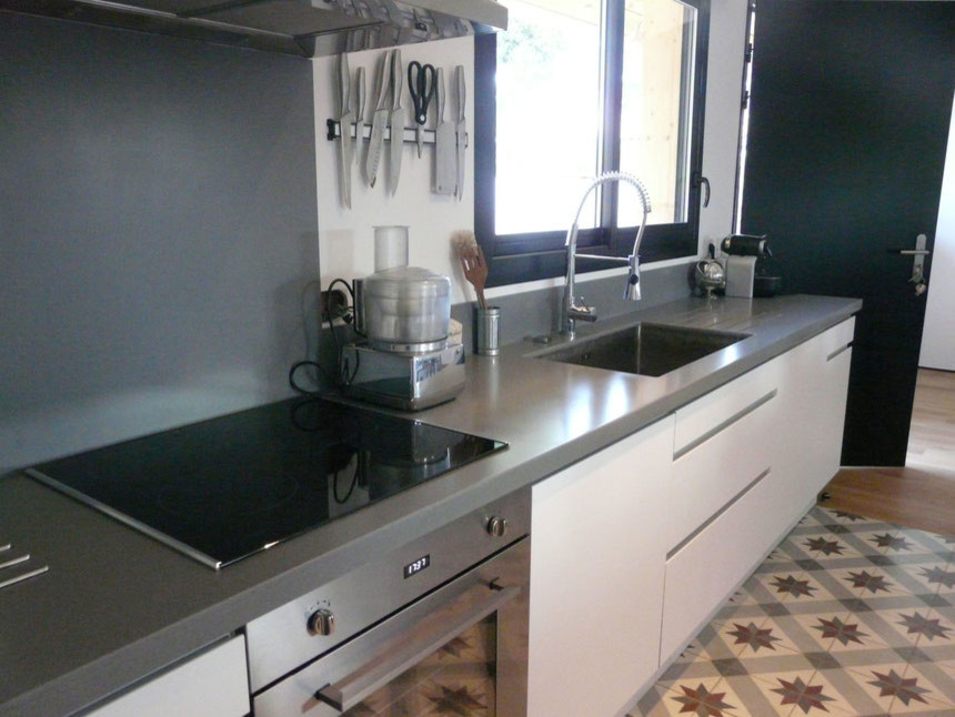 Foto di una cucina minimal con lavello integrato, top in superficie solida, paraspruzzi grigio e elettrodomestici in acciaio inossidabile