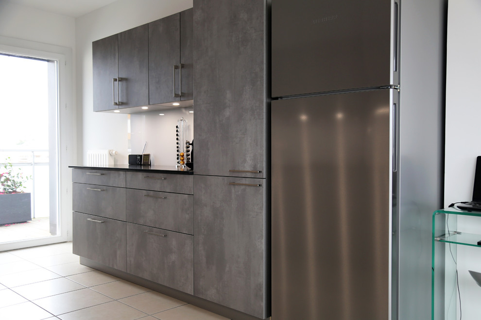Foto di una cucina minimalista di medie dimensioni con top in granito, paraspruzzi bianco, elettrodomestici in acciaio inossidabile, nessuna isola e top nero