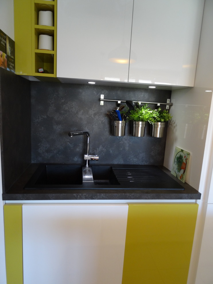 Photo of a small contemporary single-wall open plan kitchen in Marseille with a single-bowl sink, beaded cabinets, white cabinets, laminate countertops, black splashback, stainless steel appliances, ceramic flooring, an island and grey floors.