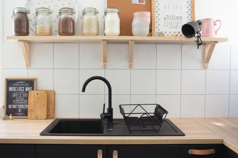 На фото: отдельная кухня среднего размера в стиле лофт с одинарной мойкой, черными фасадами, столешницей из ламината, белым фартуком, техникой из нержавеющей стали и белым полом