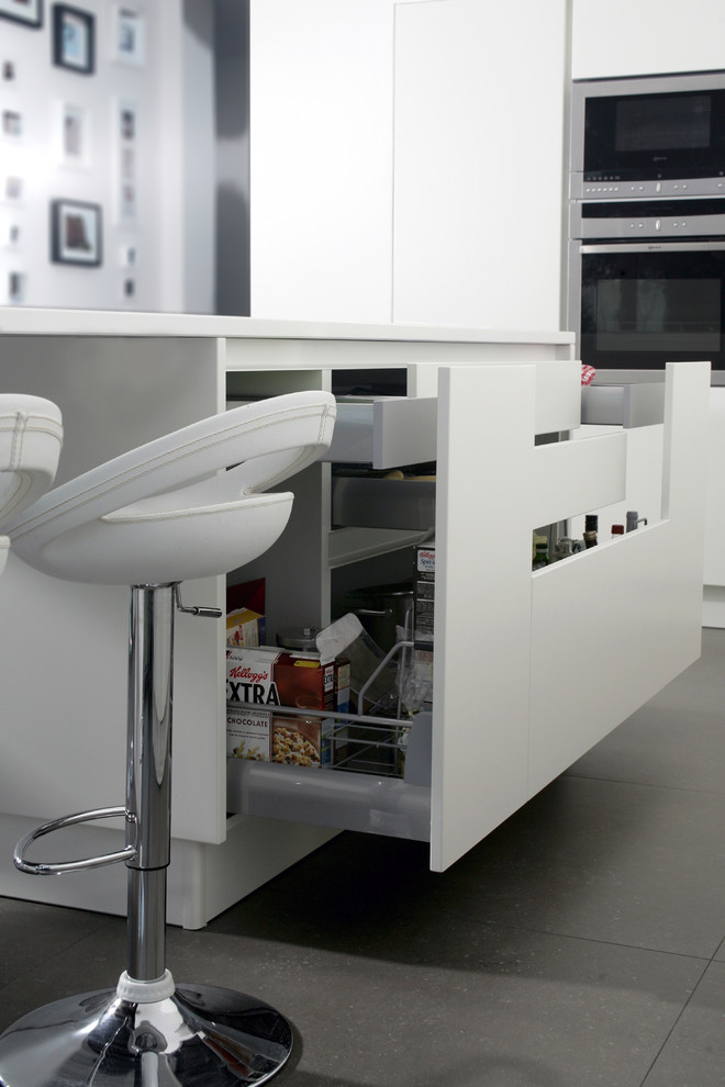 Immagine di una grande cucina moderna con lavello integrato, elettrodomestici in acciaio inossidabile e pavimento con piastrelle in ceramica
