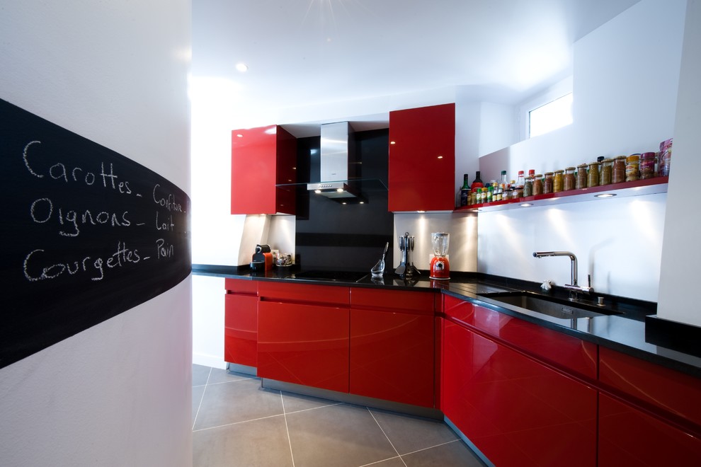 Idée de décoration pour une très grande cuisine linéaire minimaliste avec un plan de travail en granite et des portes de placard rouges.
