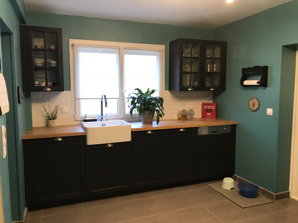 Design ideas for a medium sized retro l-shaped enclosed kitchen in Lille with a belfast sink, glass-front cabinets, dark wood cabinets, laminate countertops, white splashback, metro tiled splashback, white appliances, cement flooring, no island and grey floors.