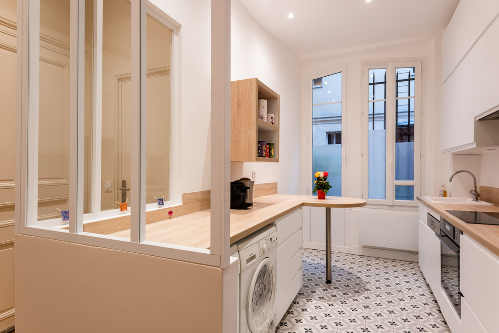 This is an example of a small contemporary single-wall enclosed kitchen in Paris with a single-bowl sink, beaded cabinets, white cabinets, wood worktops, beige splashback, wood splashback, integrated appliances, ceramic flooring, grey floors and beige worktops.