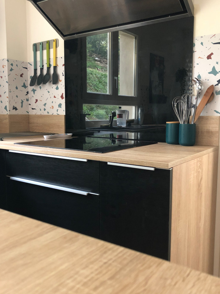 Modern inredning av ett mellanstort kök, med en enkel diskho, luckor med profilerade fronter, svarta skåp, laminatbänkskiva, flerfärgad stänkskydd, klinkergolv i keramik, en köksö och rosa golv