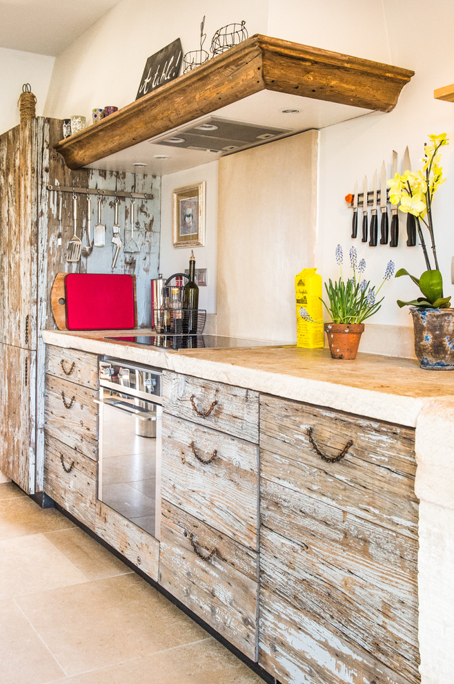 Inspiration for a medium sized eclectic single-wall enclosed kitchen in Other with distressed cabinets, beige splashback, a built-in sink, beaded cabinets, limestone worktops, limestone splashback, stainless steel appliances, limestone flooring, an island, beige floors and beige worktops.