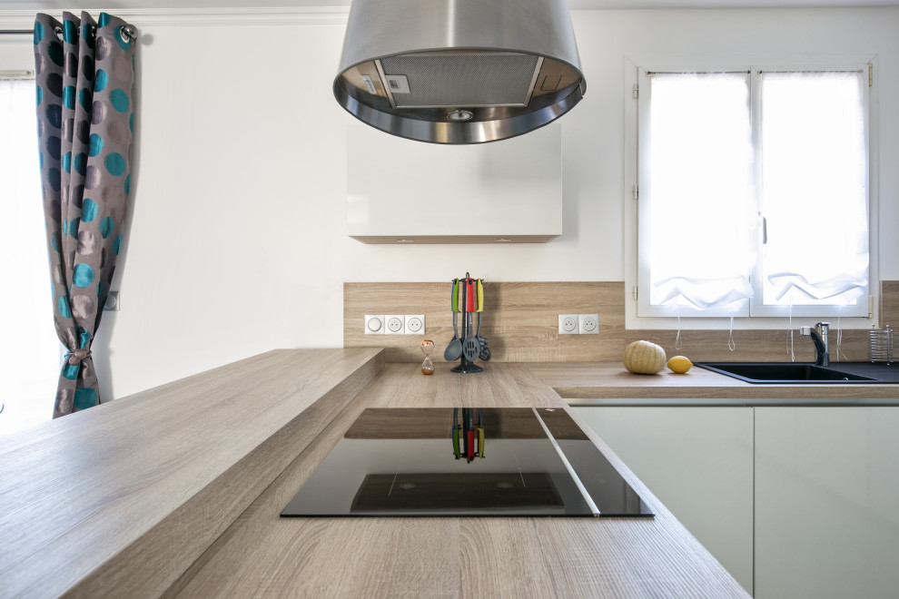 Inspiration for a large modern u-shaped open plan kitchen in Paris with a submerged sink, beaded cabinets, white cabinets, wood worktops, beige splashback, wood splashback, integrated appliances, ceramic flooring, an island, beige floors and beige worktops.