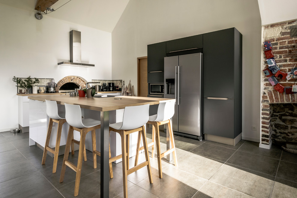 Mittelgroße Nordische Wohnküche in L-Form mit weißen Schränken, Laminat-Arbeitsplatte, Rückwand aus Zementfliesen, Küchengeräten aus Edelstahl und Kücheninsel in Angers