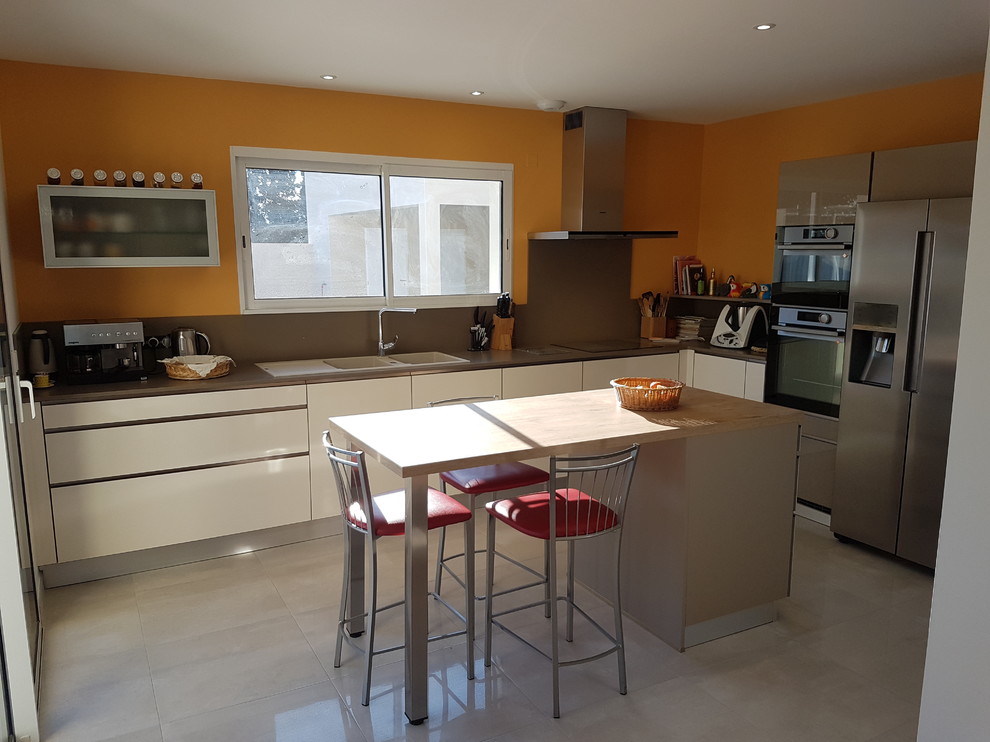 Medium sized modern u-shaped enclosed kitchen in Other with a double-bowl sink, beaded cabinets, beige cabinets, quartz worktops, integrated appliances and an island.