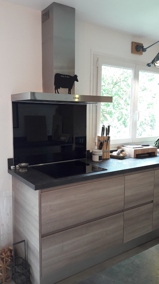 Photo of a medium sized contemporary u-shaped kitchen/diner in Lyon with light wood cabinets, laminate countertops, black splashback, glass tiled splashback, beaded cabinets, coloured appliances, laminate floors and black worktops.