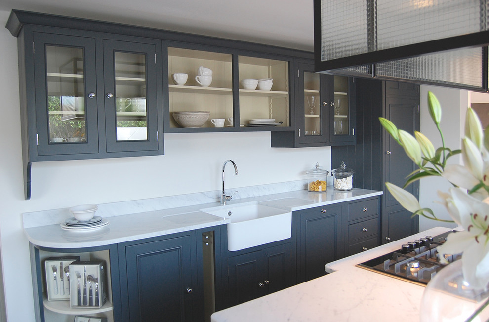 Foto de cocina campestre grande abierta con fregadero integrado, salpicadero blanco, suelo de madera en tonos medios y una isla