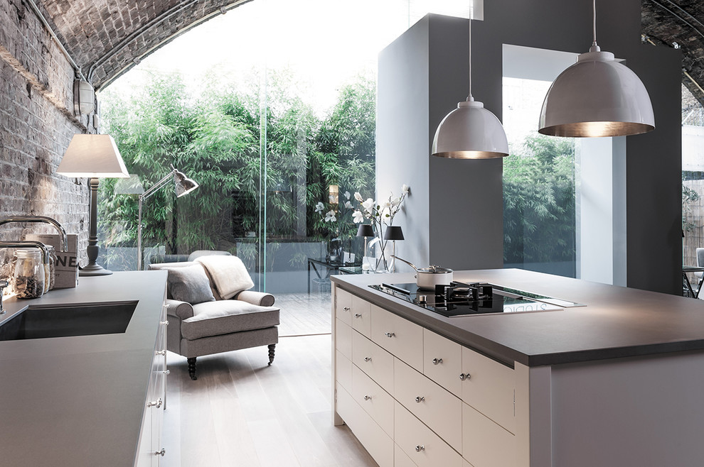 Foto di una grande cucina contemporanea con paraspruzzi in pietra calcarea, parquet chiaro e pavimento bianco