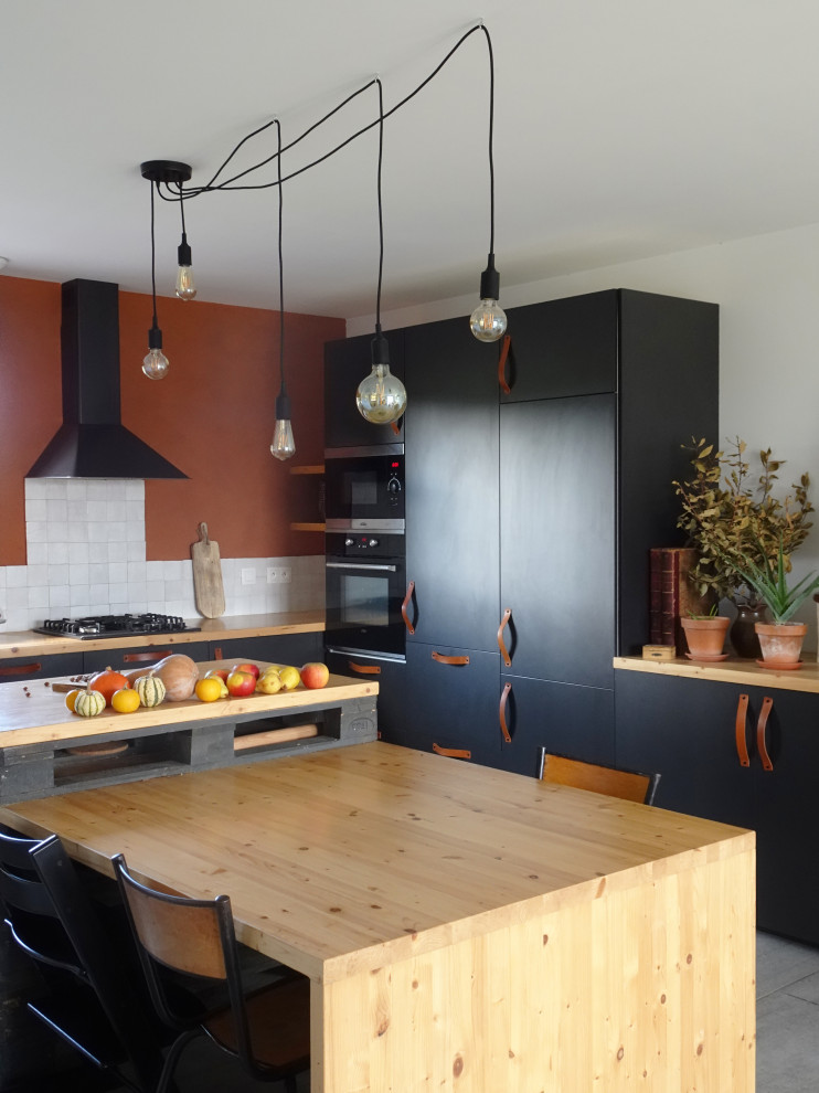 Idéer för ett stort modernt beige l-kök, med en enkel diskho, släta luckor, svarta skåp, träbänkskiva, vitt stänkskydd, grått golv och svarta vitvaror