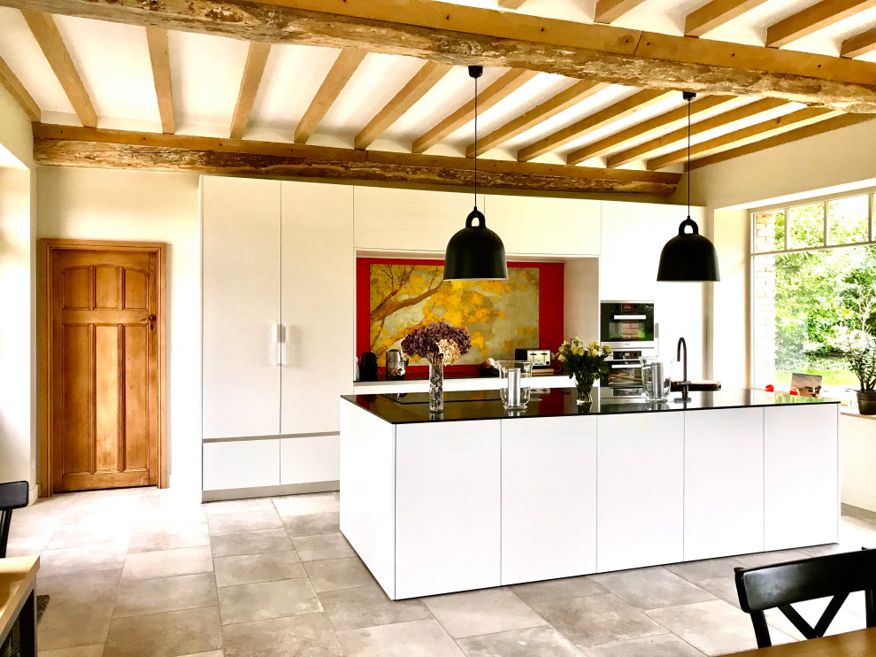 Modern inredning av ett stort linjärt kök och matrum, med en enkel diskho, vita skåp, flerfärgad stänkskydd, integrerade vitvaror, klinkergolv i keramik, en köksö och grått golv